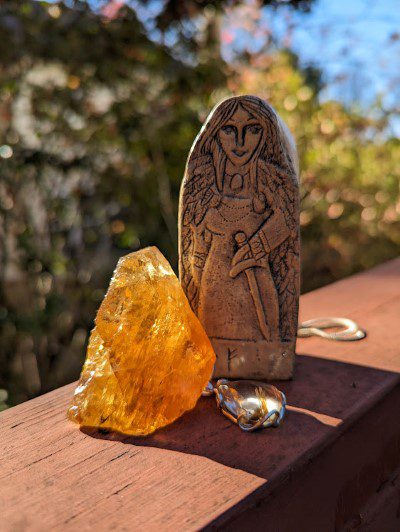 A statue and a orange stone kept on the railing with blurry background