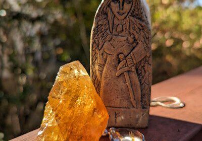 A statue and a orange stone kept on the railing with blurry background